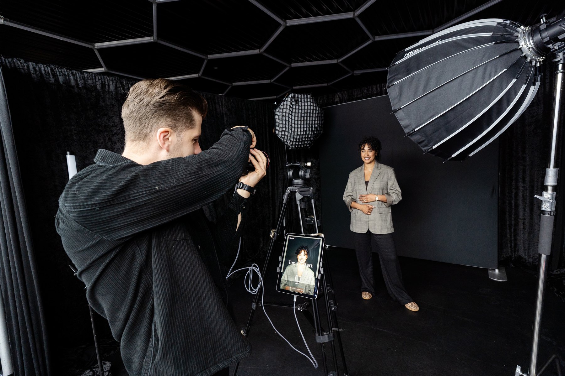 Photographer setting up professional headshots Houston black backdrop studio